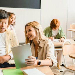 Are Tutors Worth the Money? Young teacher tutor helping her students schoolchildren pupils with homework task math exam test
