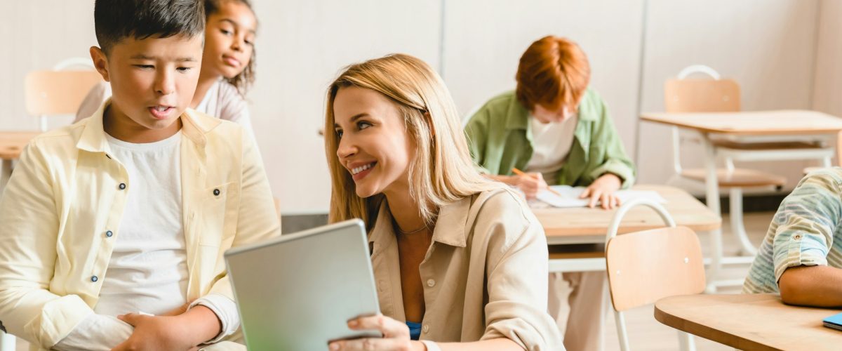 Young teacher tutor helping her students schoolchildren pupils with homework task math exam test Are Tutors Worth the Money? Young teacher tutor helping her students schoolchildren pupils with homework task math exam test
